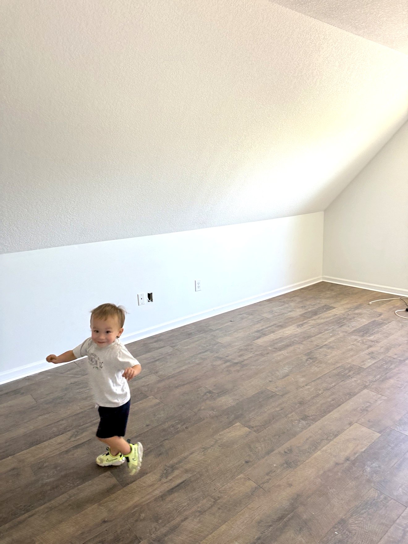 Upstairs bedroom after renovation with new luxury vinyl plank flooring and white walls